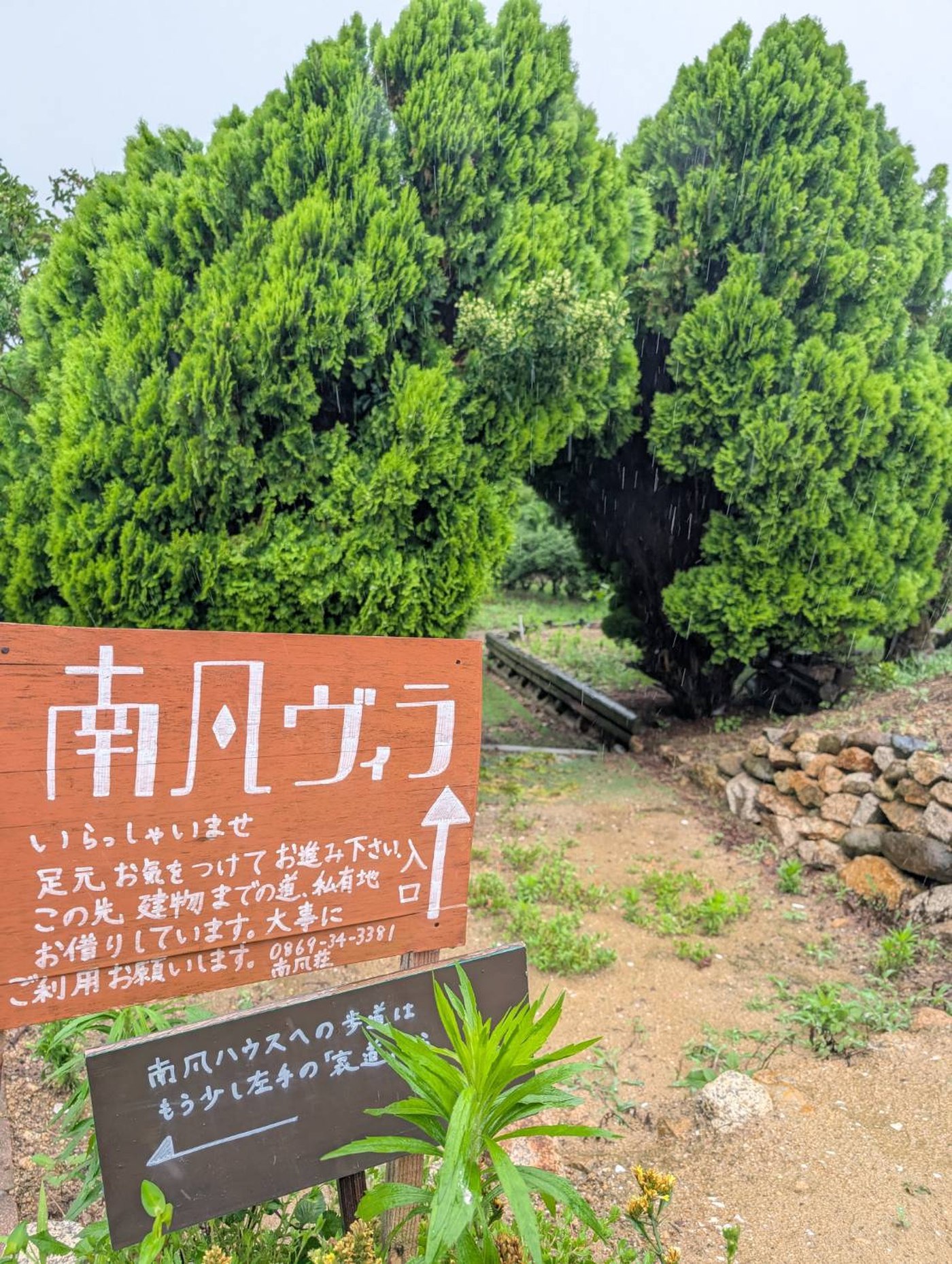 南風ヴィラの入口、看板と木々に囲まれた小道